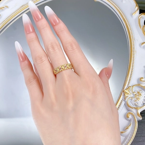 Close-up of golden lace ring with hollow geometry and purple gemstone inlay