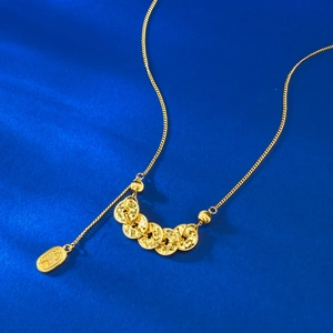 Collier chinois pièces Cinq Empereurs en or posé sur de la soie texturée bleu foncé