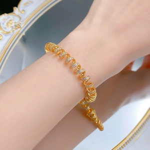 Detail of elegant gold-plated spiral bracelet with paved cubic zirconia on a wrist