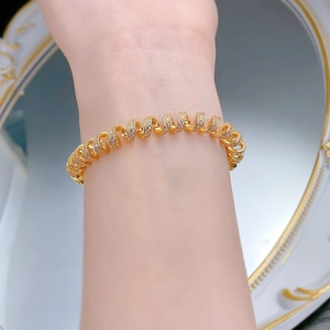 Macro shot of gold spiral bracelet with micro-paved sparkling cubic zirconia crystals