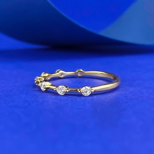 Macro shot of minimalist gold S925 silver band set with round sparkling white gems