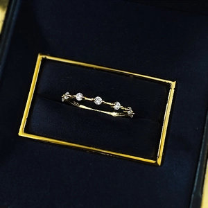 Macro detail of S925 sterling silver gold plated ring with five sparkling zircons