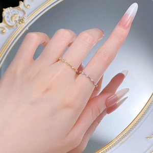 Close-up of minimalist gold and silver stacked rings with small cubic zirconia stones