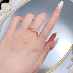 Gros plan détaillé d'une bague dorée avec diamant princesse portée par une femme