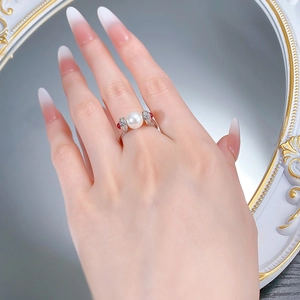 Detailed close-up of S925 silver pearl ring featuring red accent stones on finger