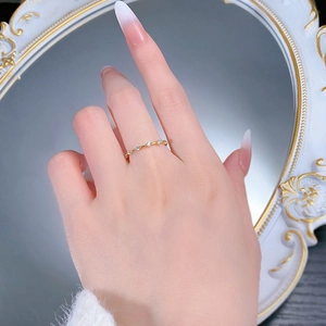 Close-up of minimalist gold-plated S925 silver ring with spaced zircon stones on finger