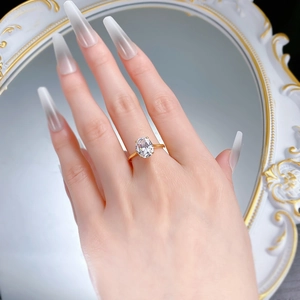 Detail of 8x10mm oval-cut zircon ring in gold claw setting worn on finger