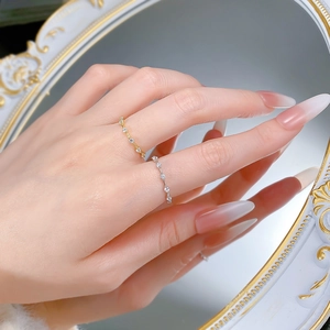 Detail of minimalist S925 silver and gold stacked rings with small zircon stones
