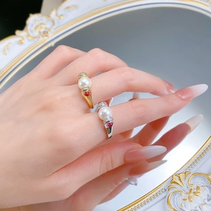 Macro shot of S925 silver vintage rings with white pearls and red gemstones on a model