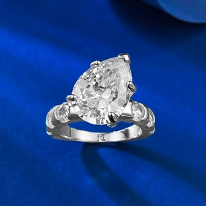 Anello in argento S925 con pietra taglio a goccia e diamanti laterali su fondo blu