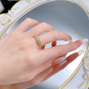 Close-up of gold-plated silver ring featuring hollow starburst pattern and white zircons