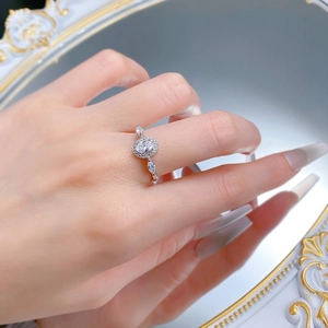 Makro-Detail eines Halo-Rings mit ovalem Schliff und Marquise-Diamanten an der Hand