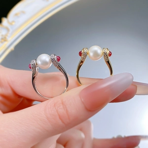 Macro detail of S925 silver and gold pearl rings with red gems and zircon accents