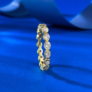 Elegant gold-plated eternity ring with pavé set cubic zirconia on a deep blue background