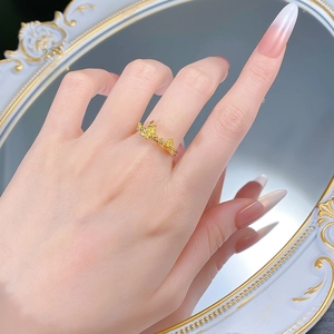 Nahaufnahme eines goldenen S925 Silberrings mit zarten Pflaumenblüten und gelben Kristallen
