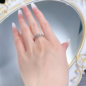 Detail of stacked S925 silver rings featuring a three-stone engagement ring and pave band