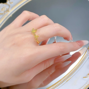 Nahaufnahme eines vergoldeten Silberrings mit Blumenmuster und Spiegelreflexion am Finger