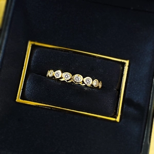 Detail of S925 silver gold-plated ring with round pavé diamonds on black velvet