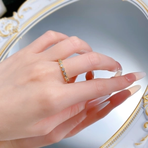 Detailed view of a gold eternity band ring with channel-set round zircon gemstones