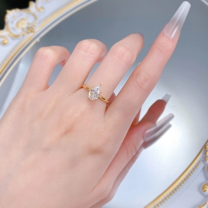 Gros plan d'une bague en zircon poire 6x9mm avec anneau doré sur le doigt