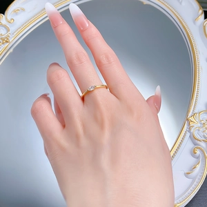 Detailaufnahme eines goldenen Rings mit einem marquise-geschliffenen Kristall am Finger