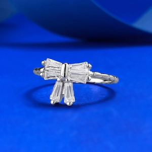 Elegant S925 silver bow ring featuring baguette-cut diamonds on deep blue background
