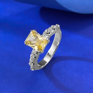 Macro shot of S925 silver ring featuring rectangular yellow gemstone and floral engraving