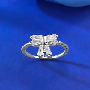 Elegant S925 silver bow ring with baguette-cut white diamonds on a navy background
