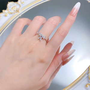 Elegant S925 silver bow ring with sparkling white zircons on a female model's hand