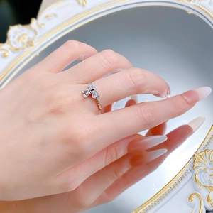 Detailed view of S925 silver bow ring with baguette-cut white stones and mirror reflection