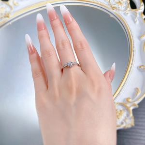S925 silver ring with round diamond and side accents shown on a hand with manicure
