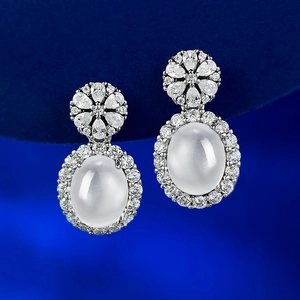 S925 Silberne Cabochon-Ohrhänger mit Zirkonia-Halo auf dunkelblauem Hintergrund
