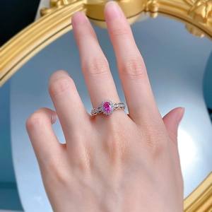Detailed view of an oval pink gemstone ring with a halo setting on an elegant wavy band