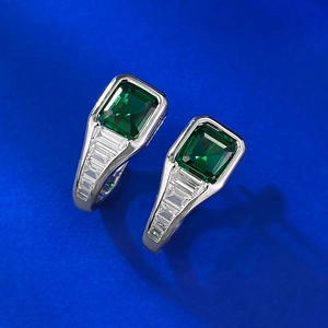 Détail de boucles d'oreilles en argent avec zircon vert taille Asscher et diamants blancs