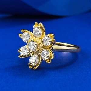Elegant gold flower ring featuring seven sparkling white zircons on a blue velvet backdrop