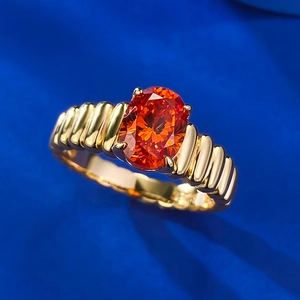 Anello in argento 925 con gemma arancione ovale e fascia dorata a coste vista macro