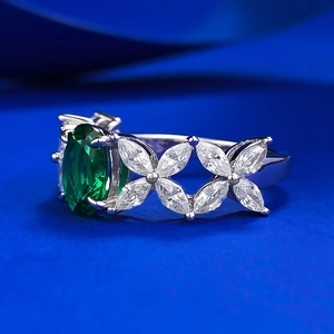 Macro detail of S925 silver ring with oval green gemstone and marquise zirconia clusters
