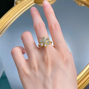 Close-up of elegant S925 silver daisy ring with gold finish and sparkling zircon stones