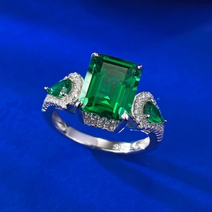 Macro d'une bague avec pierre verte taille émeraude 8x10mm et pierres latérales poire