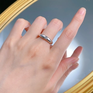 Close-up of minimalist 925 silver ring with 30-point round white diamond on a finger