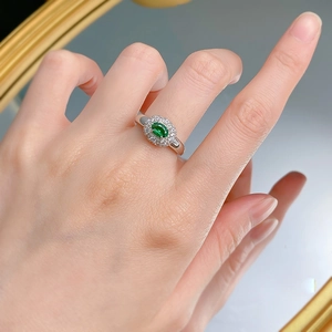 Elegant S925 silver ring featuring an oval emerald stone surrounded by white diamonds