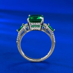 Gros plan d'une bague en argent S925 avec pierre verte taille émeraude et petits diamants