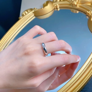 Close-up of a 925 silver ring featuring a round-cut diamond in a bezel setting worn on a hand