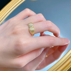 Gros plan sur la texture en métal brossé plaqué or et les zircons étincelants sur la bague
