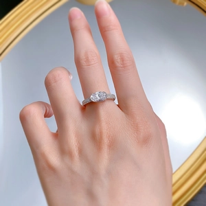 Detailed view of an oval-cut 2-carat stone ring with micro-pave silver band on a hand