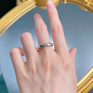 Close-up of minimalist 925 silver ring with small round diamond on hand in a mirror view
