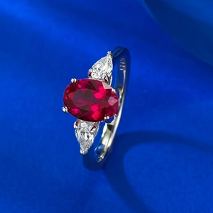 S925 silver ring featuring an oval red ruby gemstone and teardrop side stones on blue texture
