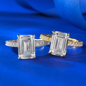 Macro detail of emerald cut rings with pave set bands in silver and gold finishes