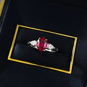 Macro detail of S925 hallmark on silver ring with oval ruby and pear-cut side stones
