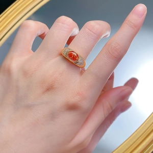 Close-up of sunset orange gemstone ring with side diamonds on model hand